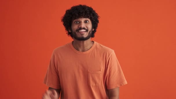 Leende Lockig Indian Vinkar Kameran Den Orange Studion — Stockvideo