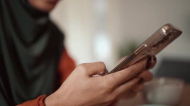Evde telefonla yazan Müslüman kadın.