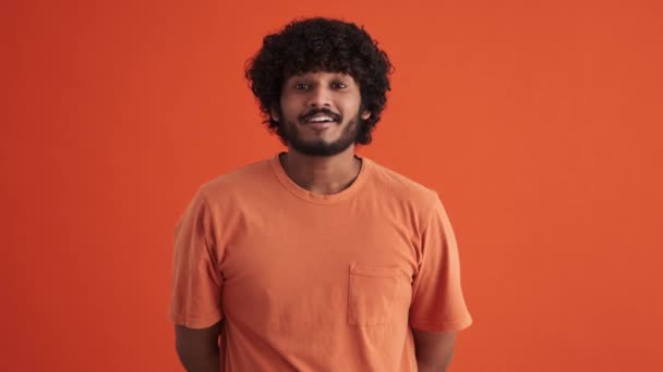 Mosolygó Göndör Hajú Indiai Férfi Egyetért Valamivel Narancssárga Stúdióban — Stock videók
