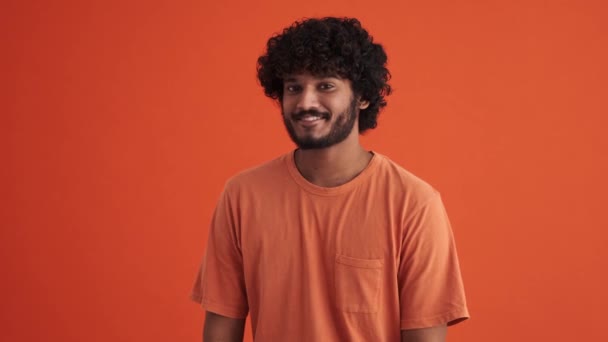 Glücklich Gelockter Indischer Mann Zeigt Herzförmige Geste Die Kamera Orangefarbenen — Stockvideo
