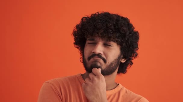 Fröhlich Lockiger Indischer Mann Mit Einer Idee Orangefarbenen Studio — Stockvideo