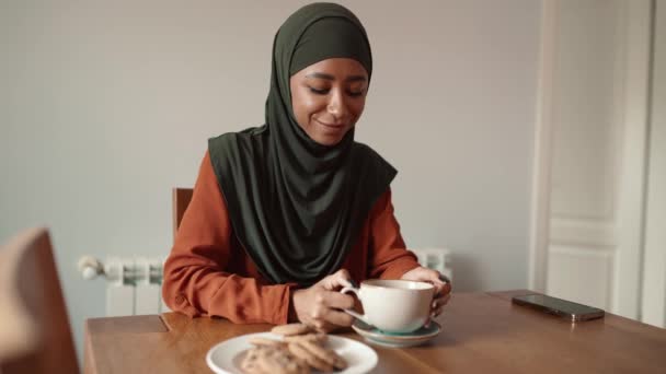 Cheerful Muslim Woman Drinking Tea Eating Cookie Home — Stock Video