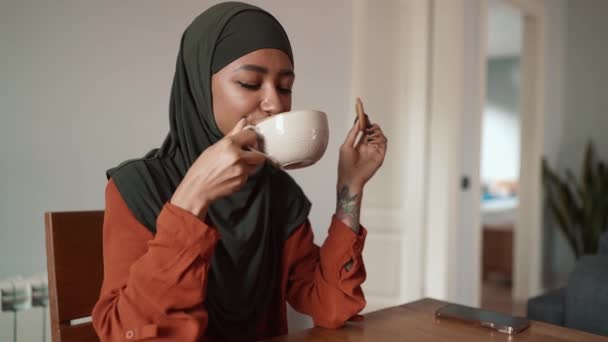 Mulher Muçulmana Sorrindo Bebendo Chá Comendo Biscoito Casa — Vídeo de Stock