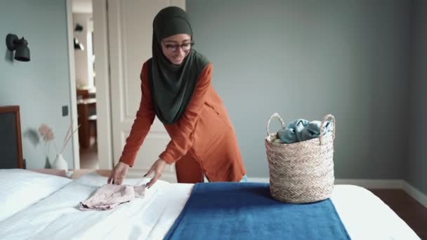 Positiv Muslimsk Kvinne Med Briller Som Stabler Ting Sofaen – stockvideo