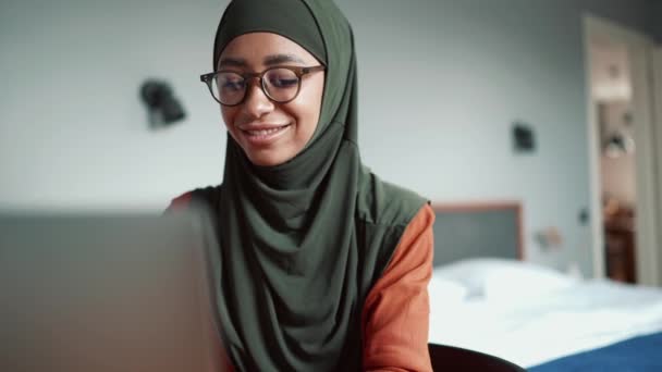 Muçulmana Mulher Positiva Vestindo Óculos Digitando Por Laptop Casa — Vídeo de Stock