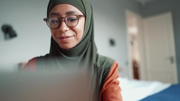 穆斯林漂亮女人 戴着眼镜 在家里用笔记本电脑打字 — 图库视频影像