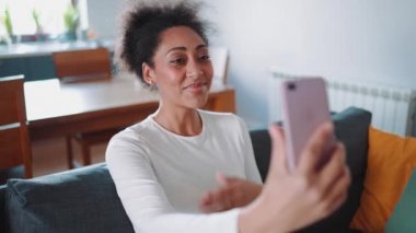 Şirin Afrikalı hamile kadın telefonda videoyla konuşuyor.