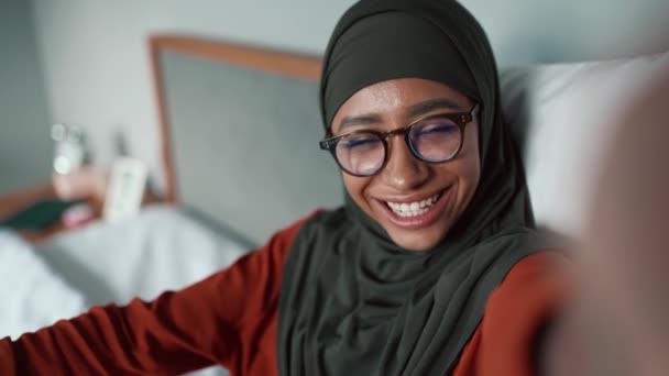 Musulmana Sonriente Mujer Usando Gafas Soplando Aire Beso Cámara Casa — Vídeos de Stock