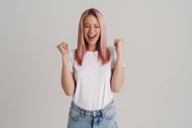 Heyecanlı genç bir kadın çığlık atıyor ve kazanan jest yapıyor beyaz arka planda izole edilmiş.