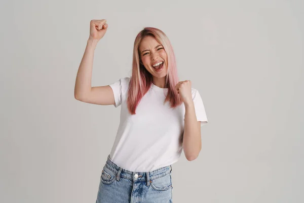 Young excited woman screaming and making winner gesture isolated over white background