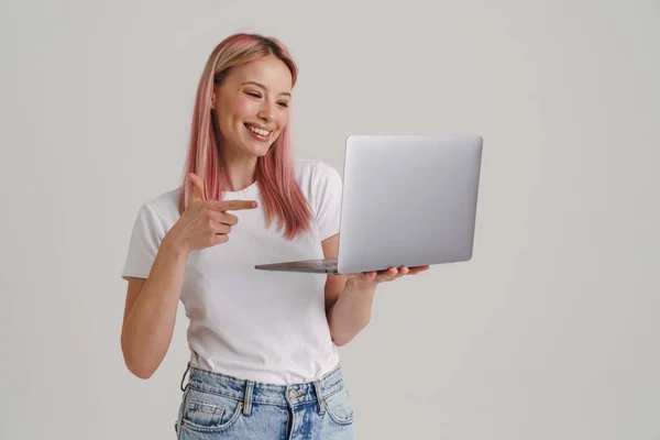 Jovem Mulher Sorrindo Enquanto Segurando Apontando Dedo Para Laptop Isolado — Fotografia de Stock