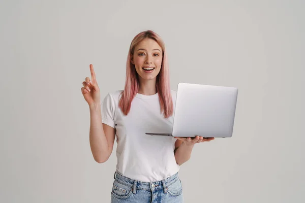 Jovem Mulher Sorrindo Enquanto Segurando Laptop Apontando Dedo Para Cima — Fotografia de Stock
