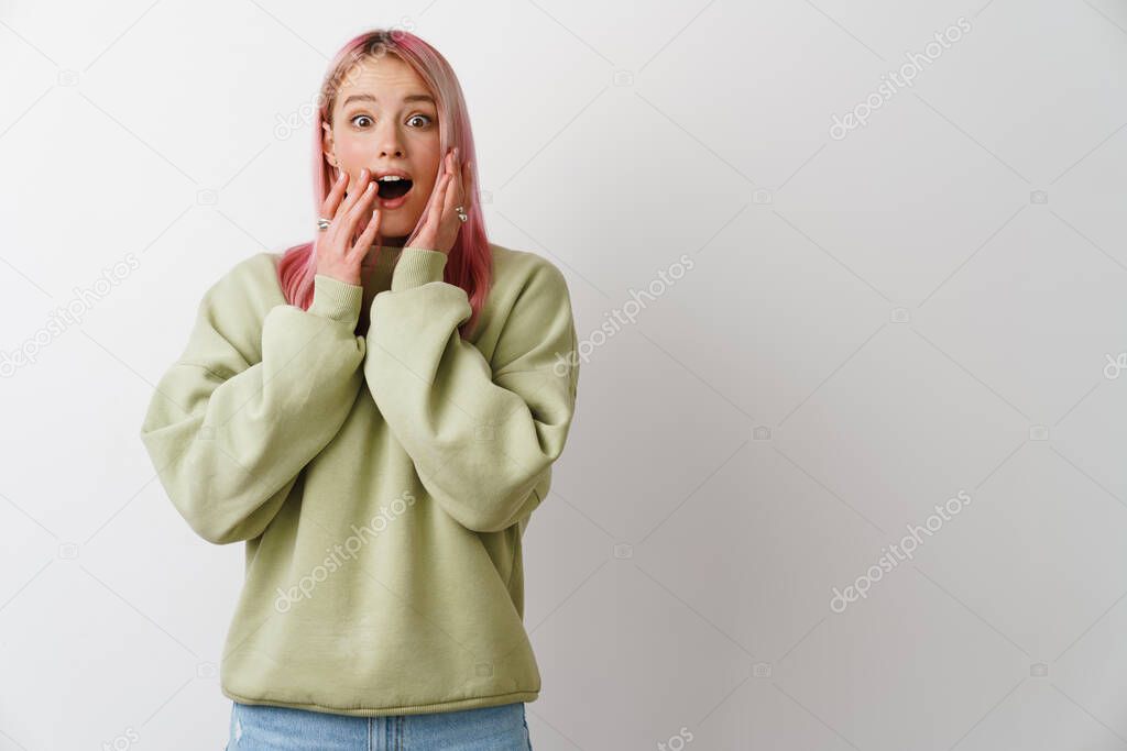 Young excited woman with pink hair expressing surprise at camera isolated over white background