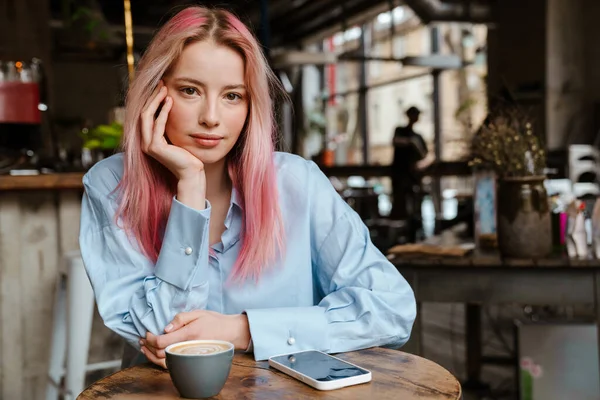 Młoda Kobieta Różowymi Włosami Patrząc Aparat Podczas Siedzenia Kawiarni — Zdjęcie stockowe