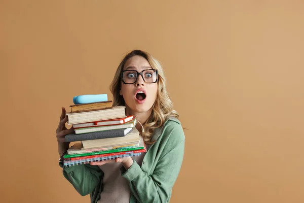 Zszokowana Piękna Kobieta Okularach Pozuje Książkami Planistami Odizolowanymi Beżowej Ściany — Zdjęcie stockowe