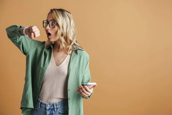 Mujer Hermosa Conmocionada Mirando Reloj Pulsera Uso Teléfono Móvil Aislado — Foto de Stock