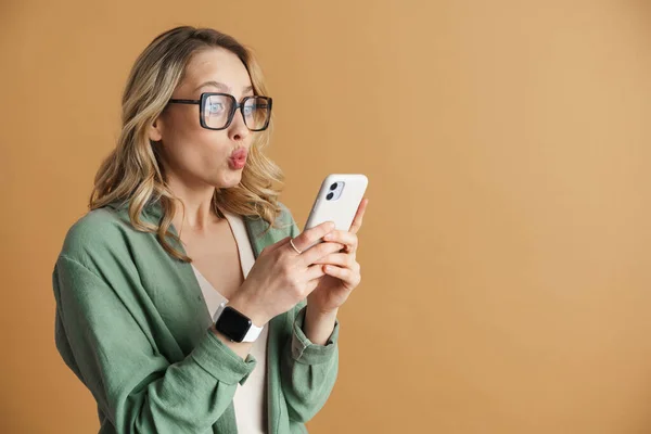 Шокована Красива Жінка Робить Губи Поцілунків Використовує Мобільний Телефон Ізольовано — стокове фото