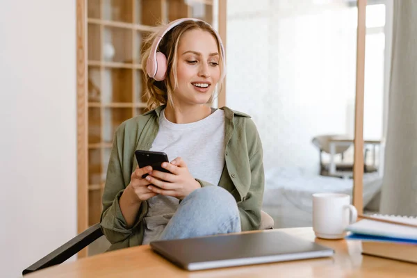 Evde Cep Telefonu Kulaklıkla Müzik Dinlerken Gülümseyen Genç Bir Kadın — Stok fotoğraf