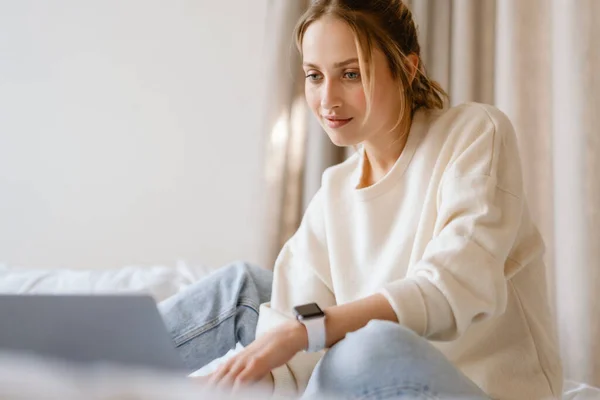 Junge Frau Arbeitet Mit Laptop Und Lächelt Hause Schlafzimmer — Stockfoto