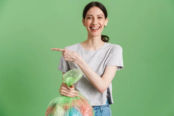 Mujer Joven Señalando Con Dedo Lado Mientras Posa Con Bolsas — Foto de Stock