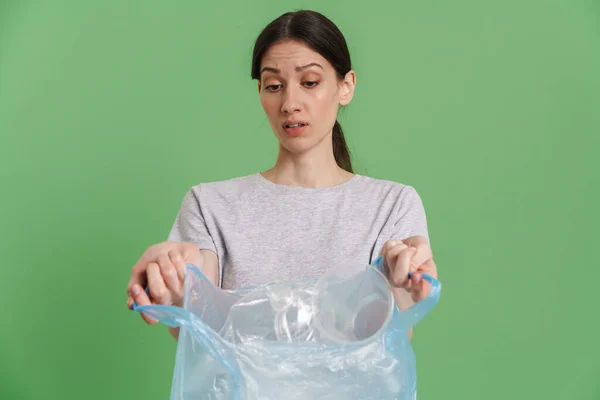 Νεαρή Μελαχρινή Προβληματισμένη Γυναίκα Που Δείχνει Πλαστικά Απορρίμματα Που Απομονώνονται — Φωτογραφία Αρχείου