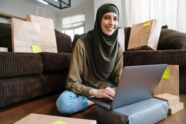 Mulher Muçulmana Feliz Hijab Sentado Sofá Casa Abrindo Caixas Papelão — Fotografia de Stock