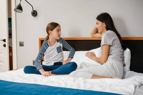 Mãe Bonita Feliz Filha Falando Enquanto Sentado Cama Casa — Fotografia de Stock