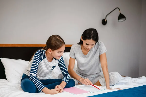 Schöne Schöne Mutter Und Tochter Machen Hausaufgaben Während Sie Hause — Stockfoto