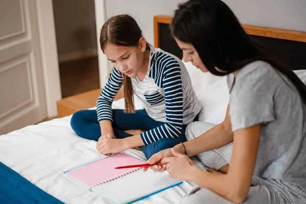 Schöne Schöne Mutter Und Tochter Machen Hausaufgaben Während Sie Hause — Stockfoto
