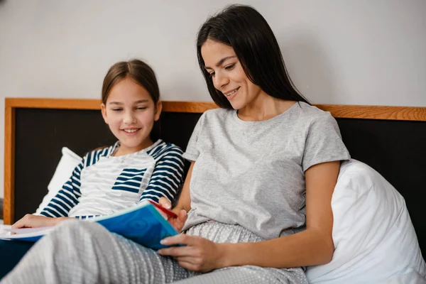 Gelukkig Moeder Dochter Het Doen Van Huiswerk Terwijl Liggend Bed — Stockfoto