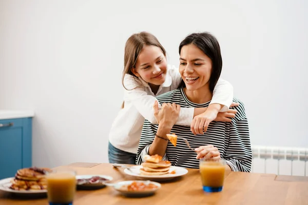 Cheerful Beautiful Mother Daughter Hugging While Having Breakfast Cozy Kitchen — Stock Photo, Image