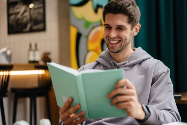 Sonriente Joven Leyendo Libro Mientras Estudia Cafetería Interior —  Fotos de Stock