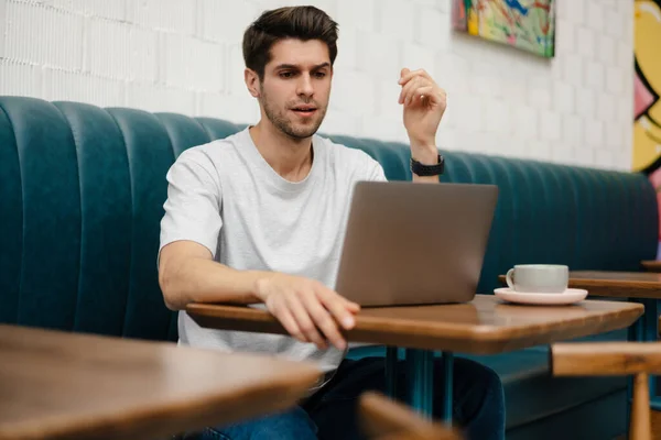 Estudiante Joven Confundido Sentado Cafetería Interior Con Computadora Portátil Estudiando —  Fotos de Stock