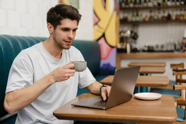 Улыбающийся Молодой Человек Сидит Кафе Помещении Ноутбуком — стоковое фото