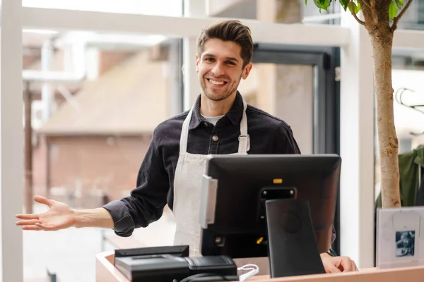 Jeune Homme Souriant Dans Tablier Debout Caisse Enregistreuse Intérieur — Photo