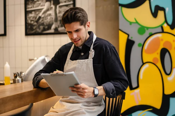 Jeune Serveur Vérifiant Qualité Des Marchandises Avec Bloc Notes Cafétéria — Photo