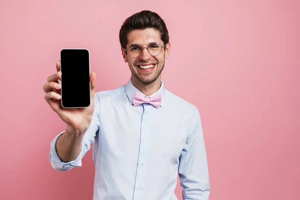 Ung Vit Man Bär Fluga Leende Och Visar Mobiltelefon Isolerad — Stockfoto