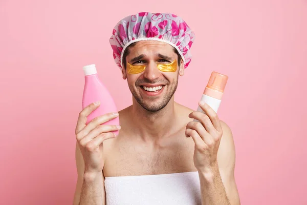 Jonge Blanke Man Met Douchepet Poseren Met Schoonheidsproducten Geïsoleerd Roze — Stockfoto