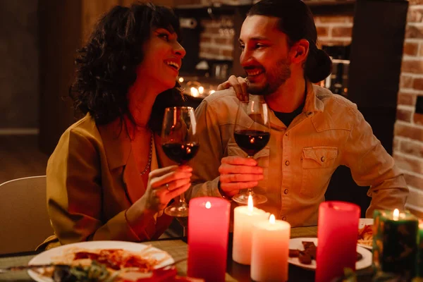 White couple laughing while having romantic dinner at home indoors