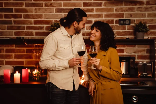 家の中でワインを飲んでいる間に話して笑っている白いカップル — ストック写真