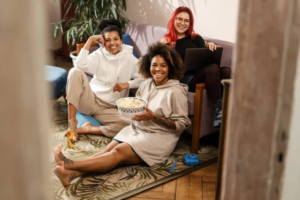 Tre Giovani Felici Mix Race Donne Amiche Sedute Divano Bere — Foto Stock