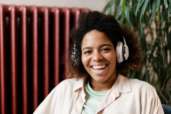 Jovem Negra Sorrindo Enquanto Ouve Música Com Fone Ouvido Casa — Fotografia de Stock