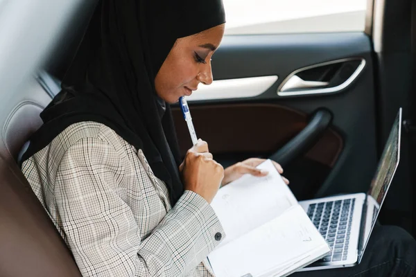 Černá Muslimka Nosí Šátek Pracuje Plánovačem Notebookem Při Jízdě Autě — Stock fotografie