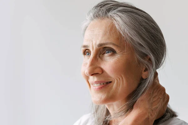 Mulher Sênior Cinza Shirt Sorrindo Enquanto Olha Para Lado Isolado — Fotografia de Stock