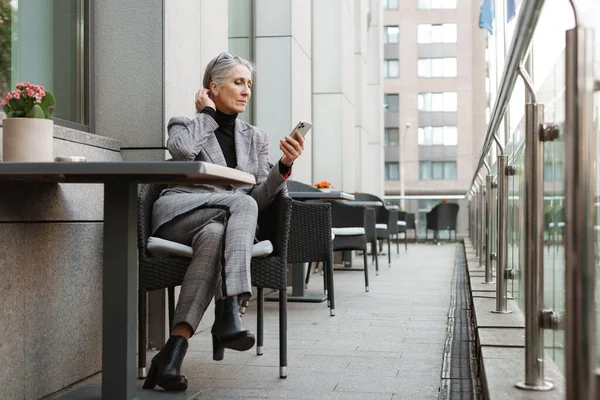 Gris Mujer Mayor Blanca Usando Teléfono Móvil Mientras Está Sentado — Foto de Stock