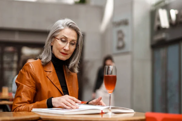 Grey Biały Senior Kobieta Czytanie Książki Podczas Picia Wina Kawiarni — Zdjęcie stockowe