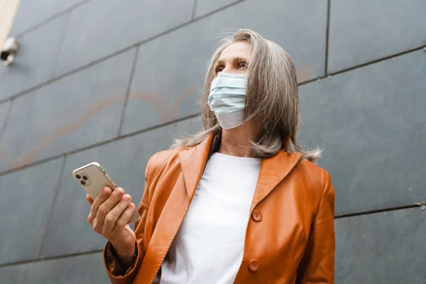 Mulher Sênior Cinza Máscara Facial Usando Telefone Celular Livre — Fotografia de Stock
