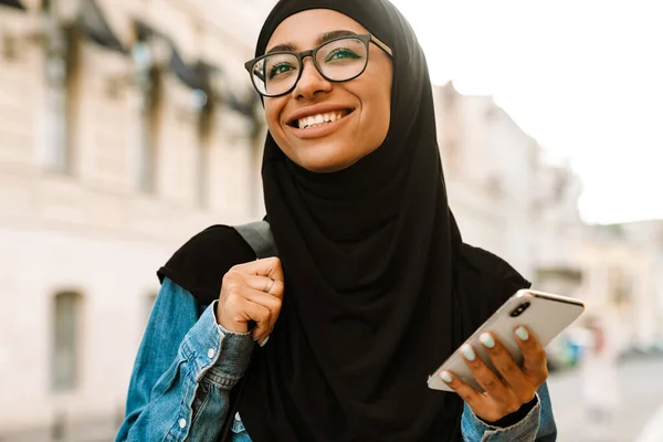 Mladá Muslimka Nosí Hidžáb Úsměvem Pomocí Mobilního Telefonu Ulici — Stock fotografie
