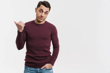 Genç esmer adam beyaz arka planda izole edilmiş bir şekilde işaret ediyor.