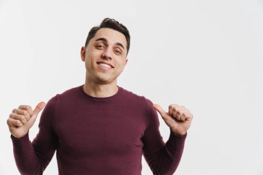 Beyaz arka planda kendini gösteren genç beyaz adam gülümsüyor.